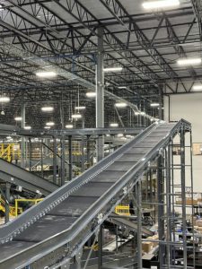 Downhill sloping conveyor in a warehouse