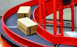 red spiral conveyor moving two boxes down an incline spiral