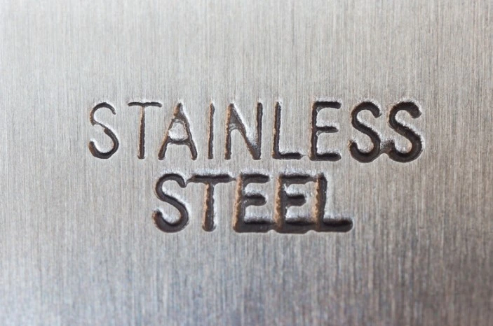 the words "stainless steel" stamped into a piece of stainless steel