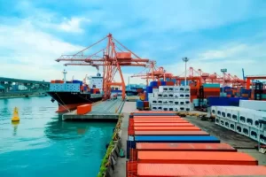 cargo ship in a sea port, showing a crane onboard that is a form of automation in material handling and logistics.