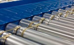 close-up of conveyor rollers against a blue background